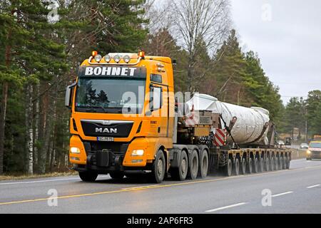 Gelb MAN TGX Bohnet GmbH semi tieflader Hols industrielle Ausrüstung wie übergroße Ladung von Begleitfahrzeugen begleitet. Raasepori, Finnland. Jan 17, 2020 Stockfoto