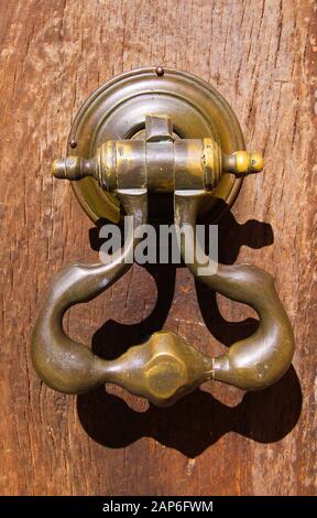 Nahaufnahme der Tür aus altem Metalleisen am Eingang aus altem Holz in hellem natürlichem Sonnenlicht - Provence, Frankreich Stockfoto