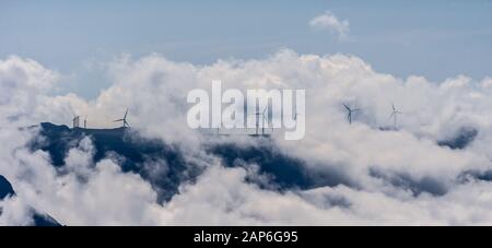 Windkraftanlage auf der Bergkuppe mit dramatischen Wolken installiert Stockfoto