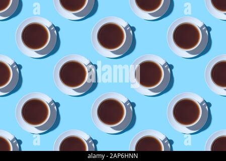 Muster der Tassen schwarzen Kaffee oder Tee auf einem blauen Hintergrund. Stockfoto