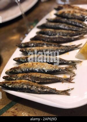 Platte mit frittierten Sardinen und Zitrone Stockfoto