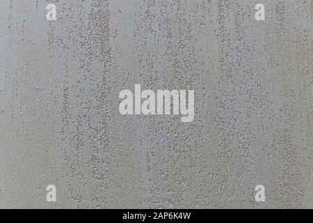 Beige mit perlmuttneutralem Putzhintergrund mit groben Aussparungen innen und glatter Struktur nach außen. Stockfoto
