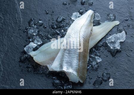 Zwei rohe Walmfilets, Merlangius merlangus, aus einem im Ärmelkanal gefangenen Whiting auf Stab und Linie von einem Boot. Das Bild zeigt Fleisch und Haut Stockfoto