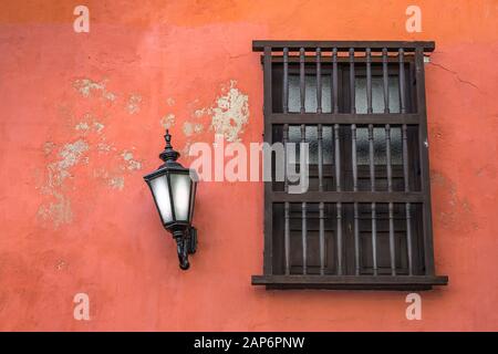 Fenster im spanischen Stil an der orangefarbenen Wand mit Laterne Stockfoto