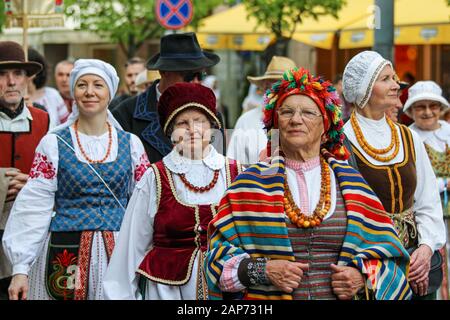 Ältere und jüngere Frauen in Volkstrachten paradieren in den Straßen von Vilnius, Litauen Stockfoto