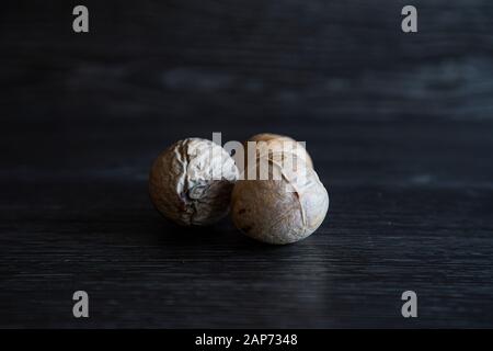 Low Key Bild von 3 verschiedenen Avocadosamen in einer Gruppe. Hartes Licht zeigt die Venen und die trockene Hautschicht der Pips. Es sind viele Details zu sehen. Stockfoto
