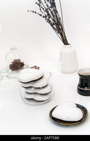 Valentinstag Stillleben mit Tasse Kaffee, Chokolate und Teller mit herzförmigem Ingwerkeks auf weißem Hintergrund. Valentines Tag Celebration Konzept Stockfoto