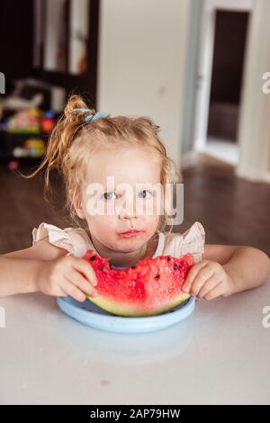 Kleines Mädchen, das eine Wassermelone isst Stockfoto