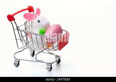 Bunte ostereier im Einkaufswagen isoliert auf weißem Hintergrund. Osterkonzept. Nahaufnahme. Stockfoto