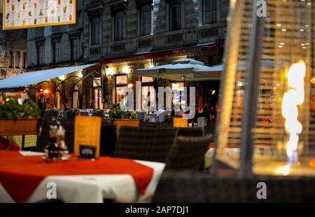 Eine Terrasse in einem Café im Freien wird spät in der Nacht von einer Flammenheizung im Touristenbereich des Diokletian Palace in Split Croatia beheizt. Stockfoto