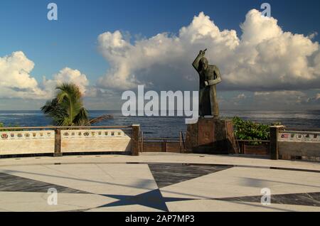 Eine Statue von Johannes dem Täufer mit einer schönen Kulisse eines trüben Atlantiks blickt auf die Plaza San Juan Bautista im Alten San Juan, Puerto Rico Stockfoto