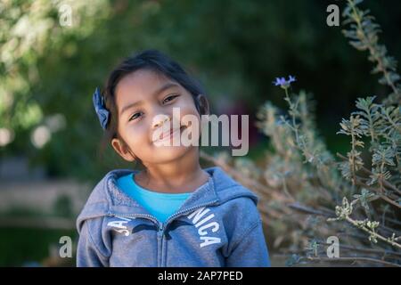 Hispanische junge Mädchen erwägen ihre Entscheidungen oder machen sich Gedanken, die im Freien mit grünen Pflanzen steht. Stockfoto