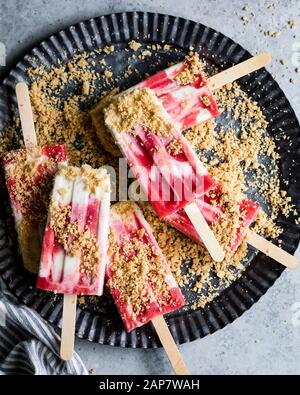 Erdbeer-Rhabarber-Pastete à la Mode Popskikel haben Erdbeer-Rhabarb-Kompott mit üppiger Vanille-Sahne und Krümel von Kuchenkruste auf Stockfoto