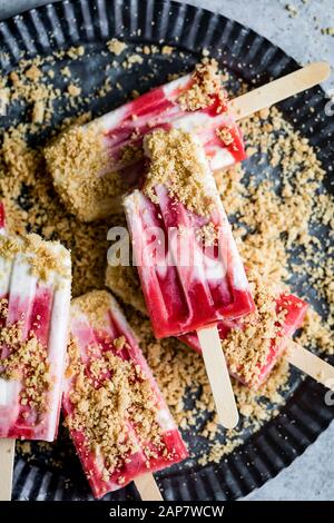 Erdbeer-Rhabarber-Pastete à la Mode Popskikel haben Erdbeer-Rhabarb-Kompott mit üppiger Vanille-Sahne und Krümel von Kuchenkruste auf Stockfoto