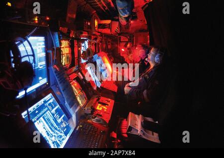 Crewmen, die an den Ufern von beleuchteten Bildschirmen im Sonarraum eines Diesel-E-U-Bootes der Collins Klasse der australischen Marine arbeiten. Stockfoto