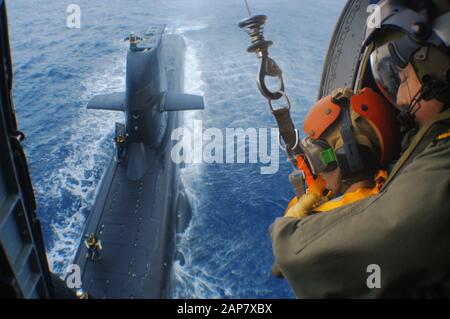 Winzarbeiten von einem Seahawk-Hubschrauber zu einem Diesel-E-U-Boot der Collins Klasse der australischen Marine. Wird als Vertikale Auffüllung bezeichnet. Stockfoto