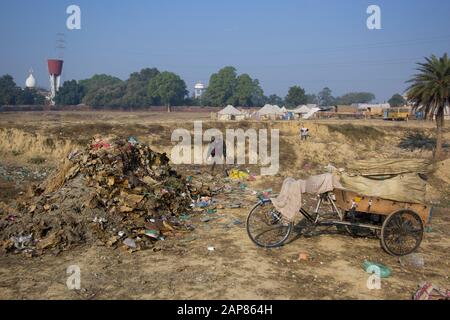 Ein paar Männer, die auf einer ländlichen Müllkippe durch den Müll gehen und nach Gegenständen suchen, die sie benutzen können. In Allalabad, Uttar Pradesh, Indien. Stockfoto