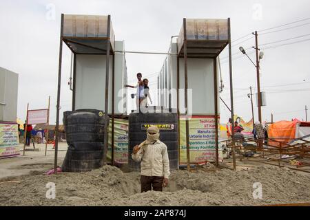 Ein Mann, der ein Loch neben einem Set von Bädern gräbt. Auf dem Hindu-Pilgerfestival Kumbh Mela in Allahabad, Uttar Pradesh, Indien. Stockfoto
