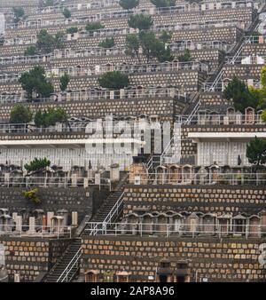 Hongkong - 9. März 2019 - Treppenaufgang auf einem Hügel mit zahlreichen Grabsteinen auf einem überfüllten Friedhof in Hongkong Stockfoto