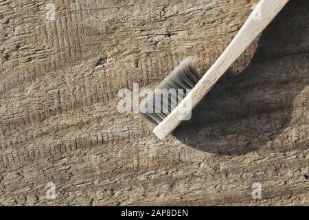 Öko Zahnbürste aus Holz. Reinigung von Zähnen ohne Abfall. Bambusbürste. Ökologiekonzept. Holzzahnbürste auf altem Holzhintergrund. Kopierbereich Stockfoto