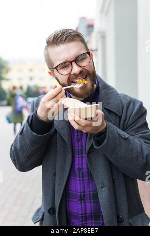 Der Mann hält Falafel-Sandwich in Papiertüte. Gesundes Straßennahrungskonzept, orientalische Küche Stockfoto