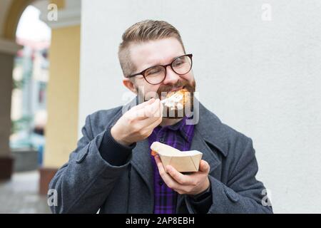 Der Mann hält Falafel-Sandwich in Papiertüte. Gesundes Straßennahrungskonzept, orientalische Küche Stockfoto