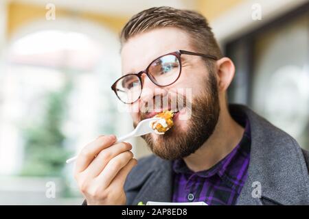 Der Mann hält Falafel-Sandwich in Papiertüte. Gesundes Straßennahrungskonzept, orientalische Küche Stockfoto