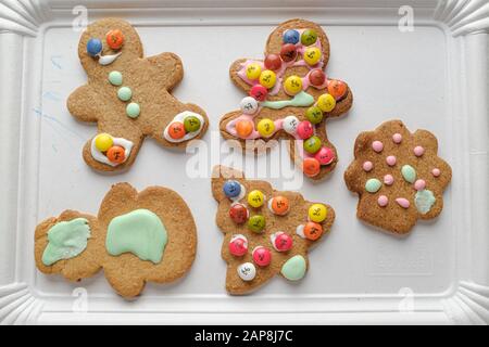 Handgefertigte Plätzchen mit Sahne und Schokolade liegen noch auf weißem Regalgrund Stockfoto