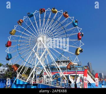 Kaohsiung, TAIWAN - 11. JANUAR 2020: Ein Riesenrad mit bunten Kabinen auf einer örtlichen Vergnügmesse Stockfoto