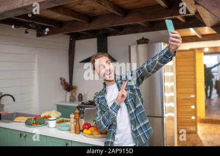 Junger Mann macht selfie in der Küche Stockfoto