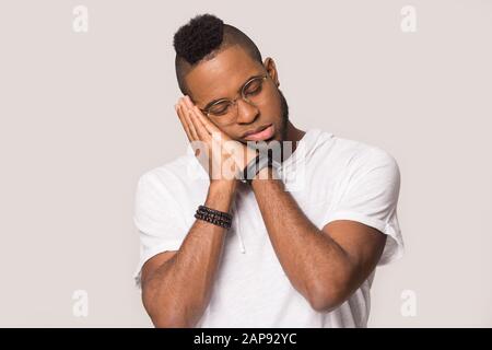 Müde schwarzer Mann in Studio schlafen Kopf auf den Händen Stockfoto