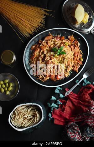 Klassische italienische Spaghetti Bolognese Sauce Pasta in einem schwarzen Gericht, gehäufte Spaghetti bolognese Draufsicht mit Zutaten zum Kochen von Pasta, leckerer Appetiz Stockfoto