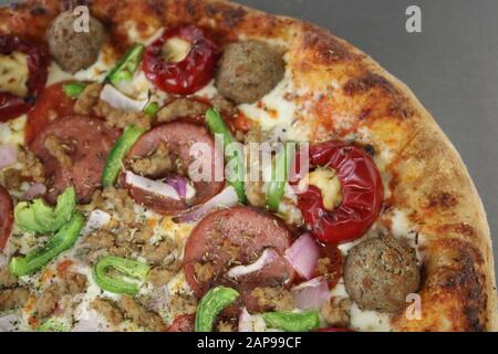 Frisch gebackene italienische Pizza, Pfefferoni, Pilze, Wursttopflecken, Pizzasauce, Mozzarella-Käse, Mitnahme oder Pizza-Lieferung im Pizza-Restaurant Stockfoto