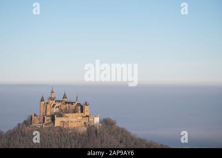 22. Januar 2020, Baden-Württemberg, Bisingen: Die Sonne scheint auf der Burg von Hohenzollern, während das dahinter liegende Land von Nebel bedeckt ist. Foto: Sebastian Gollnow / dpa Stockfoto