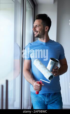 Mann, der eine kurze Pause einfing, während er einige Hausarbeiten durchgemacht hatte Stockfoto