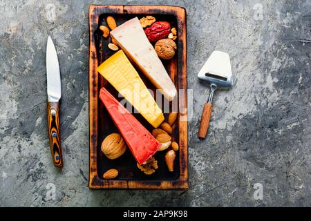 Kochplatten aus Holz mit verschiedenen Käsesorten auf dem Tisch Stockfoto
