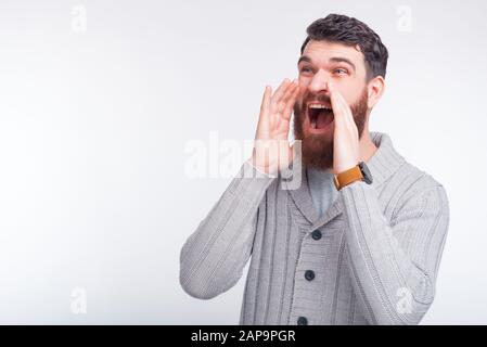 Staunter junger Mann ruft gute Nachrichten oder Werbung. Stockfoto