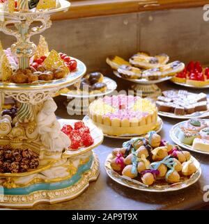 Nahansicht der Desserts in der Konditorei, die auf dem Dessertservice in Minton zu sehen ist. Dazu gehören Schokoladendiavolini, Moos-Kekse, Toraux, Profit Stockfoto