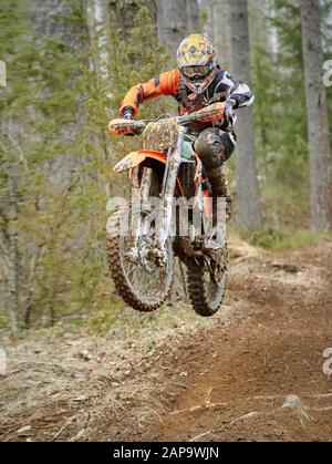 Motocross Fahrer springen mit dem Bike mit hoher Geschwindigkeit auf der Rennstrecke. Stockfoto