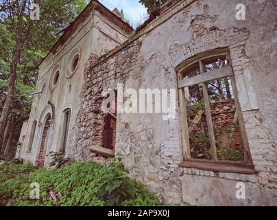 Alten, verlassenen Ruinen der St. Nikolaus Kirche in Estland. Die üppigen Laub der Bäume und Wald, die die Schönheit dieser historischen Ruine. Stockfoto