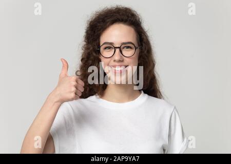 Junge glückliche Frau in Brille mit Daumen nach oben. Stockfoto