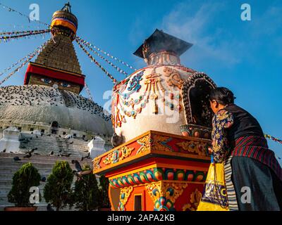 Eine alte Frau führt in Boudha Stupa eine religiöse Zeremonie durch Stockfoto
