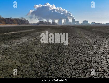 21. Januar 2020, Brandenburg, Peitz: Wasserdampf steigt aus den Kühltürmen des Braunkraftwerks Jänschwalde der Lausitz Energie Bergbau AG (LEAG), im Vordergrund ist der aufgerissene offene Grund eines abgetropften Fischteichs zu sehen. Der Fahrplan des Bundes für den Abbau der Brauner mit den Fristen für die Kraftwerke Jänschwalde und Schwarze Pumpe (beide Spree-Neiße) ist im Landkreis Brandenburg-Lausitz unterschiedlich erhalten. Nach Plänen soll das Braunkraftwerk Jänschwalde zwischen 2025 und 2028 stillgelegt werden. Zwei Blöcke waren bereits Stockfoto