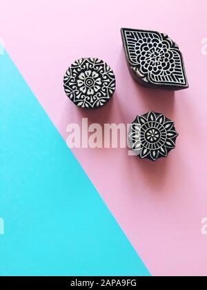 Creative Flat lagerte kalamkari Holzmarken auf pastellfarbenem Hintergrund. Blaues und rosafarbenes Pastellpapier, geometrischer flacher Laienhintergrund mit indischem kalam Stockfoto