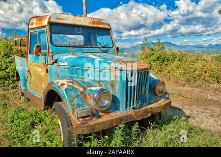 Nafplio, Peloponnes, Griechenland - 29. August 2015: Ein verrosttes Wrack von Pick-up-Wagen, das auf dem Land aufgegeben wurde und in der Landwirtschaft als Landmaschinen verwendet wird. Stockfoto