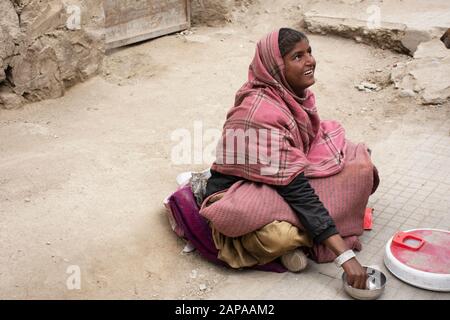 Jammu KASHMIR, INDIEN - 19. MÄRZ: Indische Frauen Bettler oder unberührbare Kaste halten Babysitter und Bettelgeld von Reisenden Menschen auf dem Markt in LEH Stockfoto