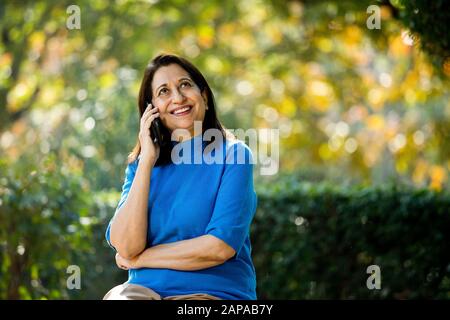 Glückliche Seniorin Textnachrichten per Handy Stockfoto