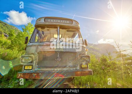 Ulvik, Norwegen, Europa - 15. Juni 2014: Autoabfuhr im Wald mit einem Wrack eines Oldtimer mit der Bezeichnung Ekstratur. Stockfoto