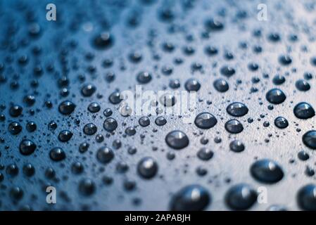 Wasser fällt auf Kunststoffoberfläche ab. Makro mit geringer Schärfentiefe. Stockfoto