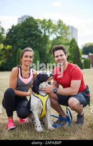 Porträt eines lächelnden Paares und ihres Hundes nach dem Workout Stockfoto